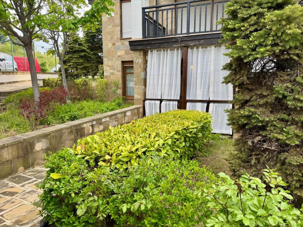 a house with a bunch of bushes in front of it at Apartment at the Seaside in Sozopol