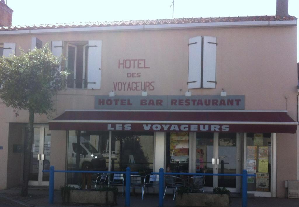 a restaurant with a sign on the side of the building at Les Voyageurs in Vairé
