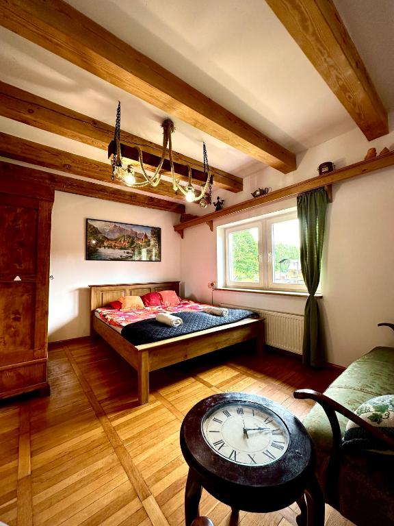 a bedroom with a bed with a clock in it at Dworek nad jeziorem z prywatną plażą in Krąg