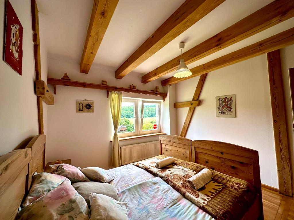 a bedroom with a bed and a window at Dworek nad jeziorem z prywatną plażą in Krąg