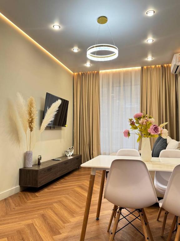 un soggiorno con tavolo e sedie bianchi di Центр города 2 room meridian apartments super new modern a Almaty