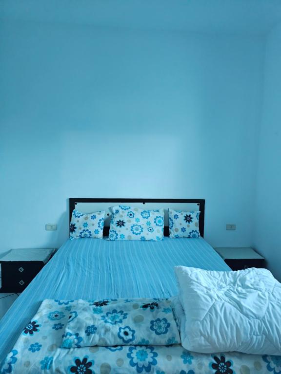 a bedroom with a bed with a blue light at Casa blu ghar el melh in Île Pilau