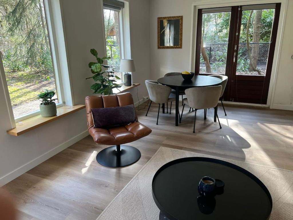 un soggiorno con un tavolo e una sedia di Forest house with sauna a Norg