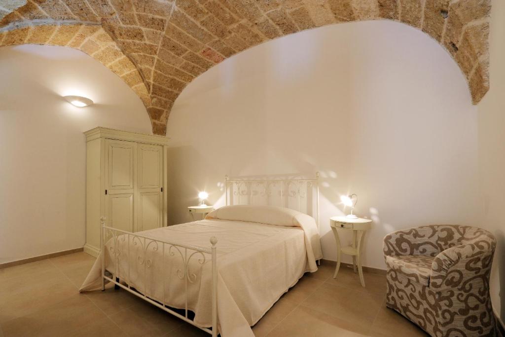 プレシッチェにあるSuite Piazzetta Villaniのベッドルーム1室(ベッド1台、椅子付)