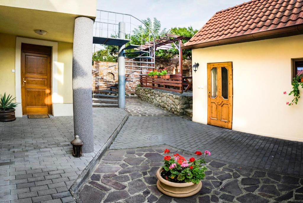 un patio de una casa con flores en una olla en Penzion Moravský sommeliér en Valtice