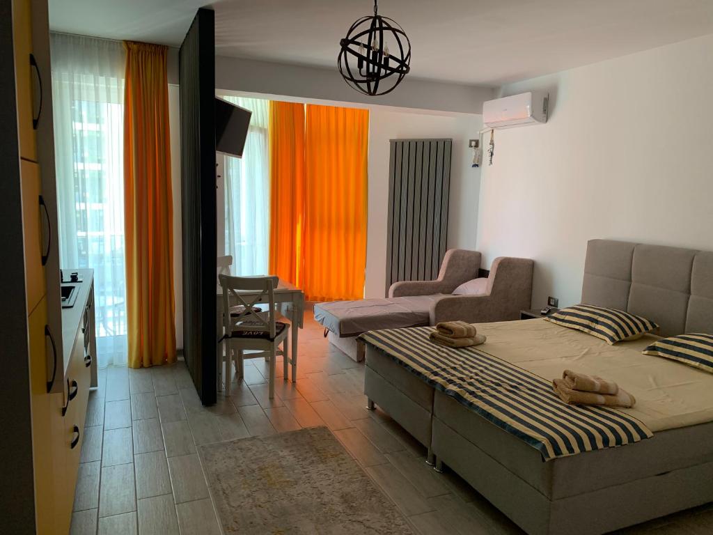 a bedroom with a bed and a living room at Black Sea View Studio & Spa & Pools Mamaia Nord in Mamaia Nord