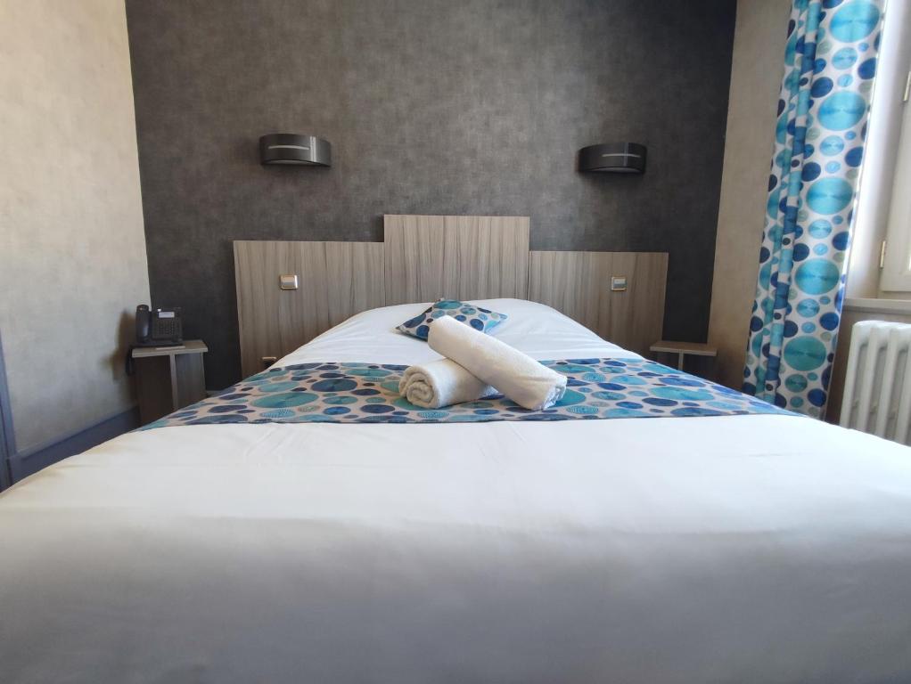 a bed with two towels on top of it at Logis Hotel Restaurant La Croix Verte in Neau