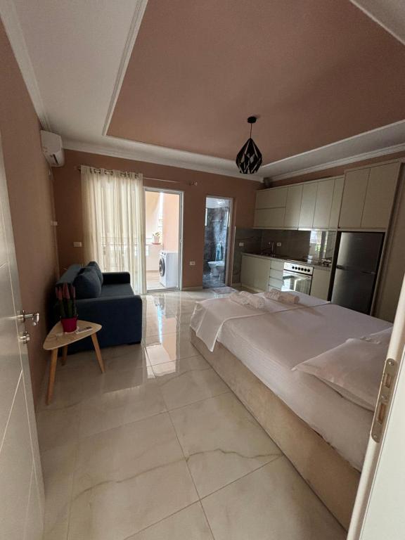 a large bedroom with a large bed and a couch at Blissful Apartments in Sarandë