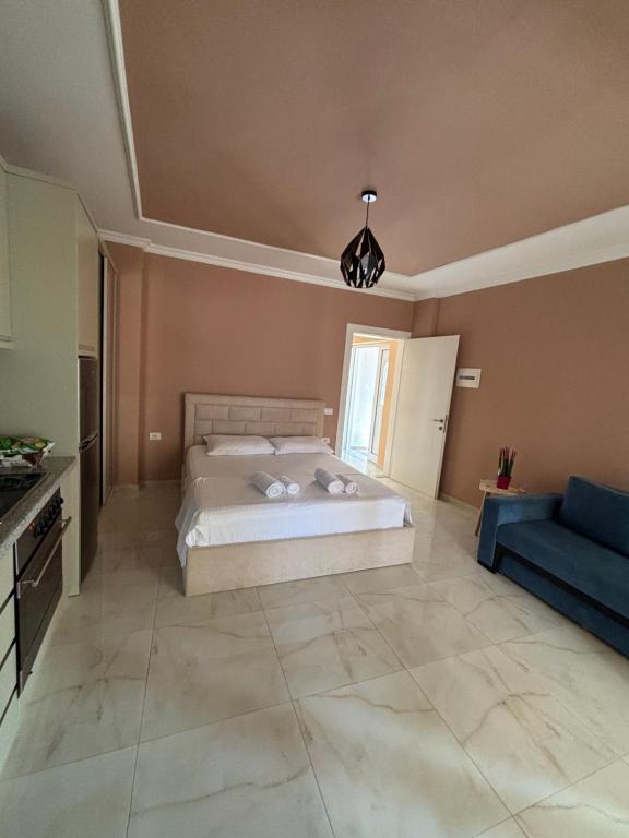 a bedroom with a bed and a blue couch at Blissful Apartments in Sarandë