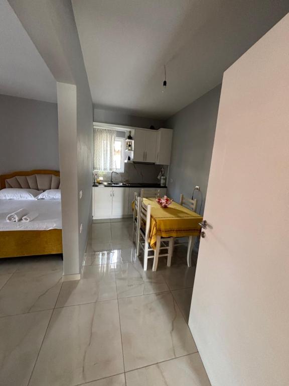 a room with a bed and a table and a kitchen at Blissful Apartments in Sarandë