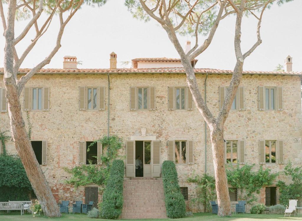 an old house with trees in front of it at La Pescaia Resort in La Pescaia