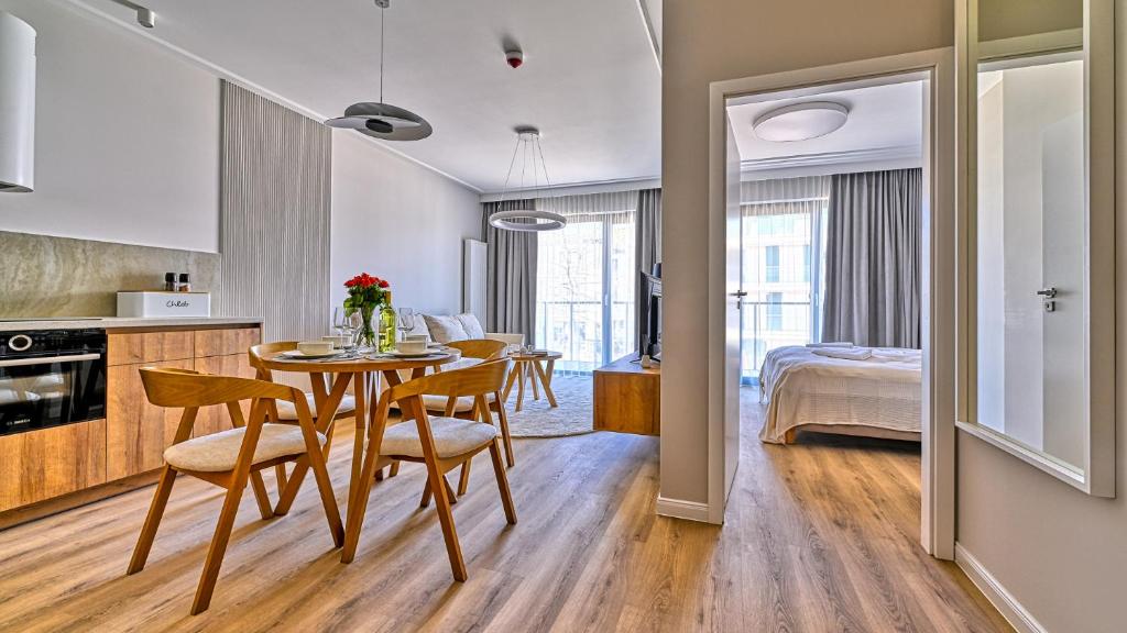 a kitchen and a dining room with a table and chairs at Rezydencja Niechorze D210 z 2 sypialniami Eco Boho - 5D Apartments in Niechorze