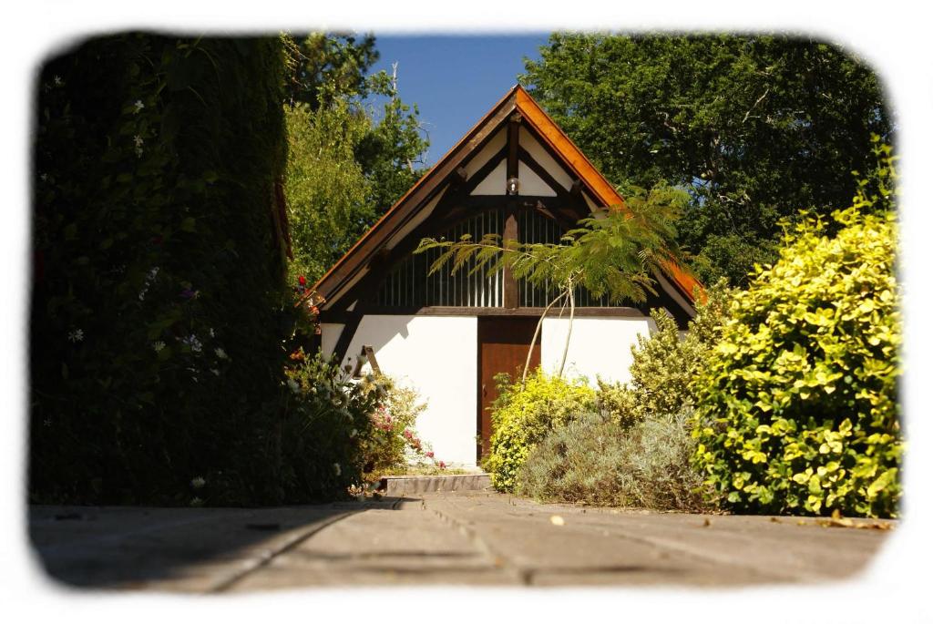 a small house with a brown roof and a white garage at Bergerie de Bazas Gîte in Lignan-de-Bazas