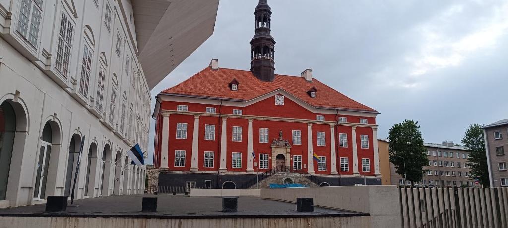 a large red building with a tower on top of it at Old Town apartment in Narva