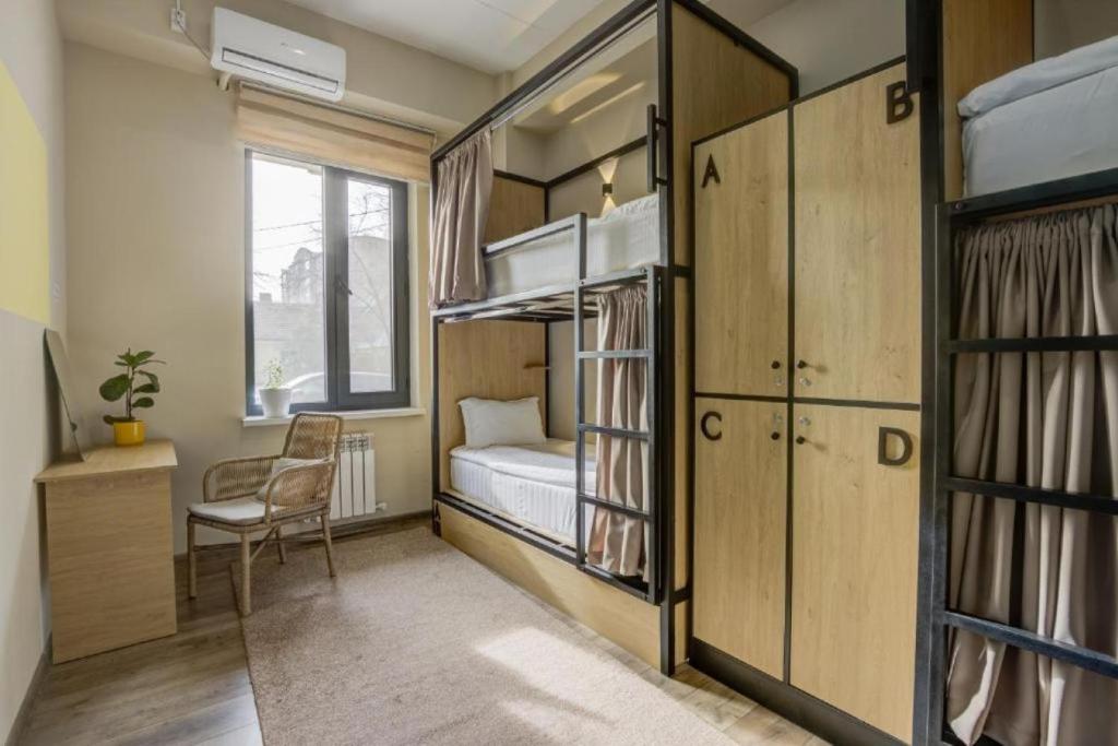 una piccola stanza con letti a castello e una scrivania di Bodo Hostel a Bishkek