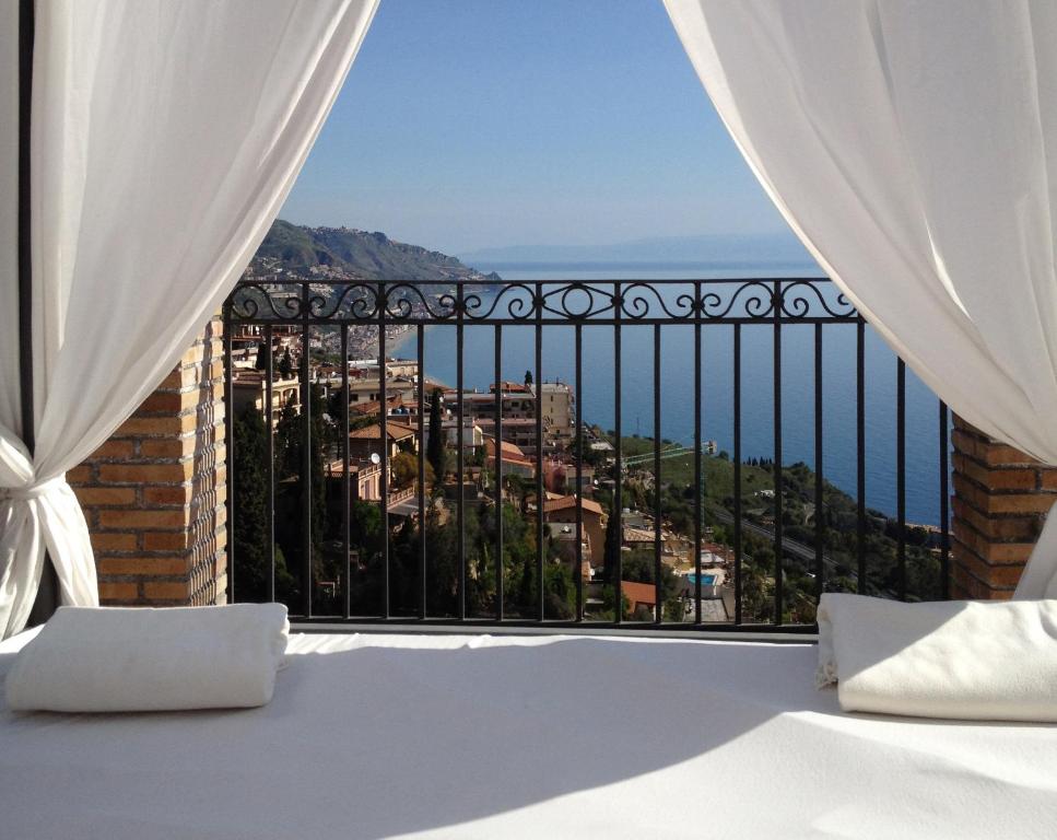a bedroom with a view of the ocean at Isoco House in Taormina