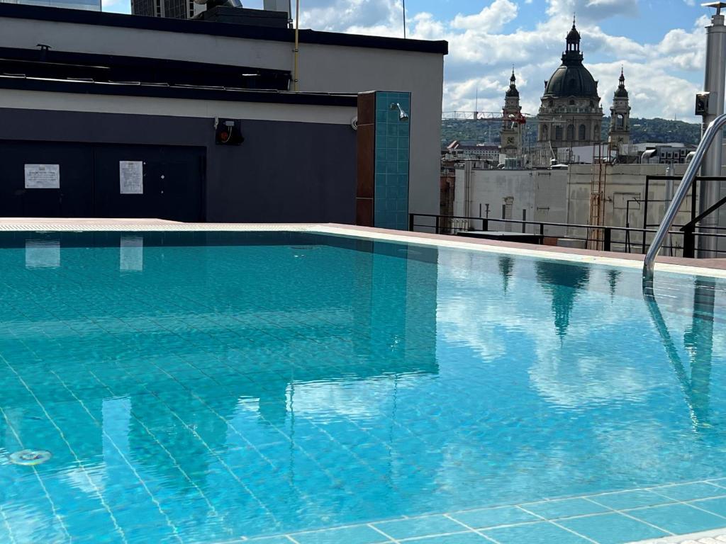a blue swimming pool on top of a building at Luxe Studio in City Center with FREE Parking in Budapest