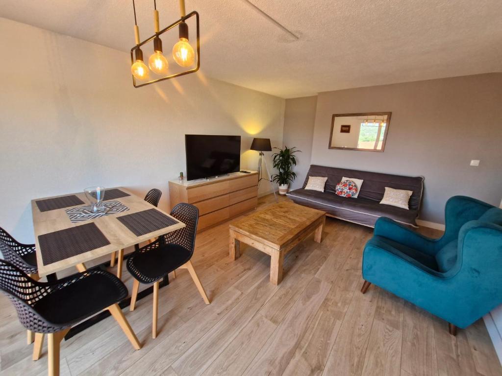 un salon avec une table à manger et un canapé dans l'établissement Le Sénèque - Fréjus - Piscine, à Fréjus