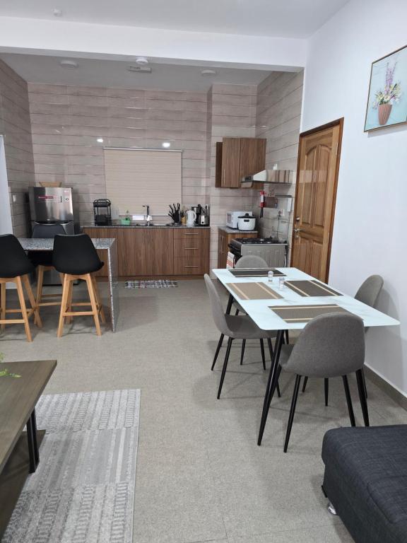 a living room with a table and chairs and a kitchen at Lovers paradise Self-catering apartments in Mahe