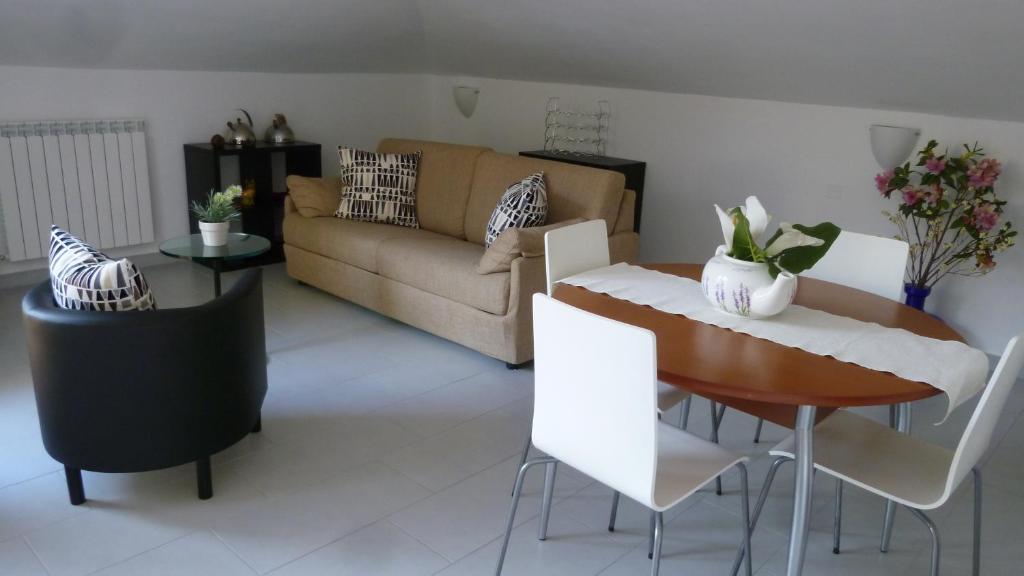 sala de estar con sofá, mesa y sillas en Chà Apartment, en Laigueglia