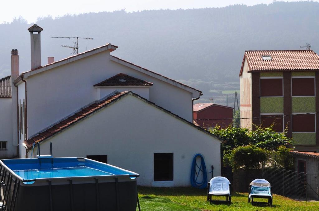 a white house with a pool in the yard at Casa da tía María , Razo , Costa da Morte in Razo da Costa