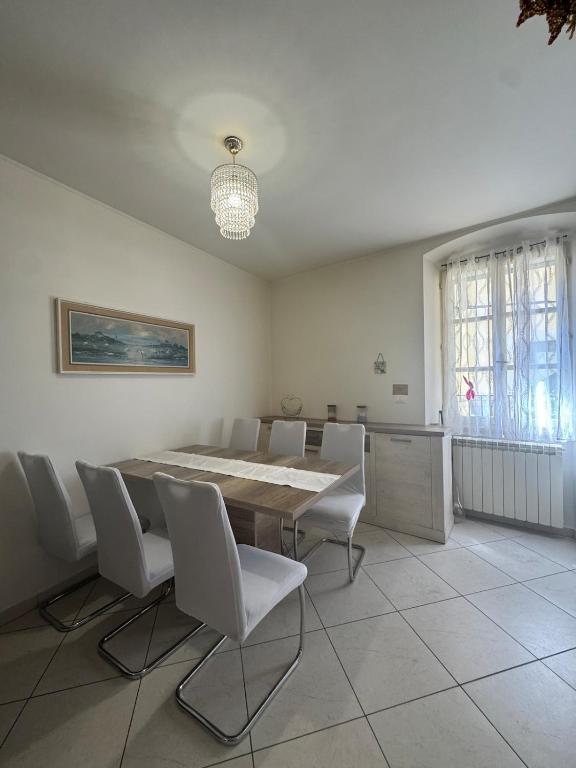 a dining room with a table and white chairs at G&E Houses in Koper