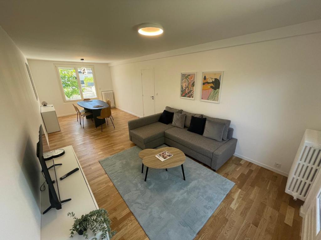 a living room with a couch and a table at Maison Cosy à Chartres in Chartres