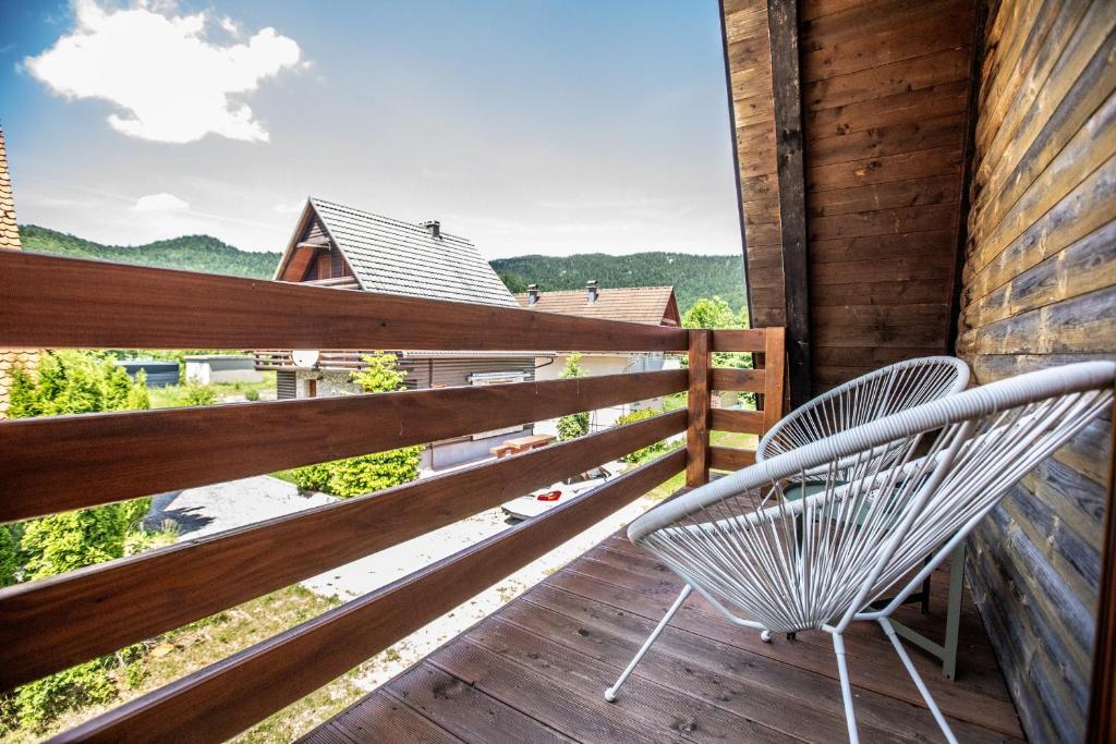 a white chair sitting on a deck with a view at Apartment Lasica for 4 persons in Jasenak
