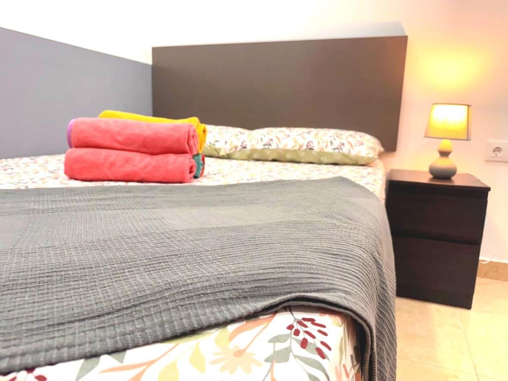 a bedroom with two beds with colorful pillows on them at 4'min to beach and tren 15 min to plaza catalunya by tren in Sant Adria de Besos