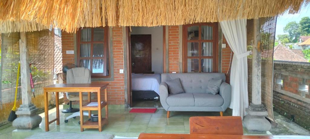 a living room with a chair and a table at Rumah Sedana Ubud Centre in Ubud