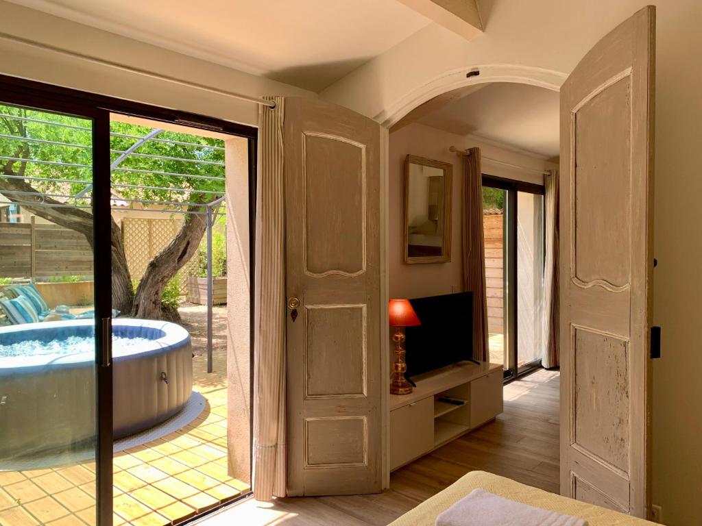 une salle de bain avec baignoire, télévision et fenêtre dans l'établissement Douillet chic flat & SPA en Provence, à Ventabren