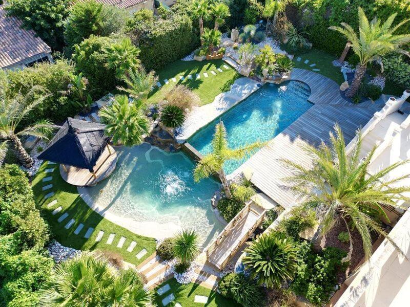 une vue aérienne d'une piscine avec des palmiers dans l'établissement Villa Halo, au Cap d'Agde
