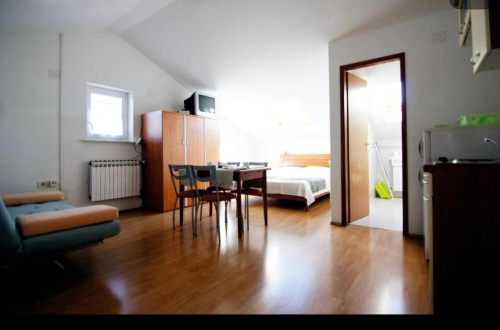 ein Wohnzimmer mit einem Tisch und ein Zimmer mit einem Bett in der Unterkunft Apartment Sofia in Cres