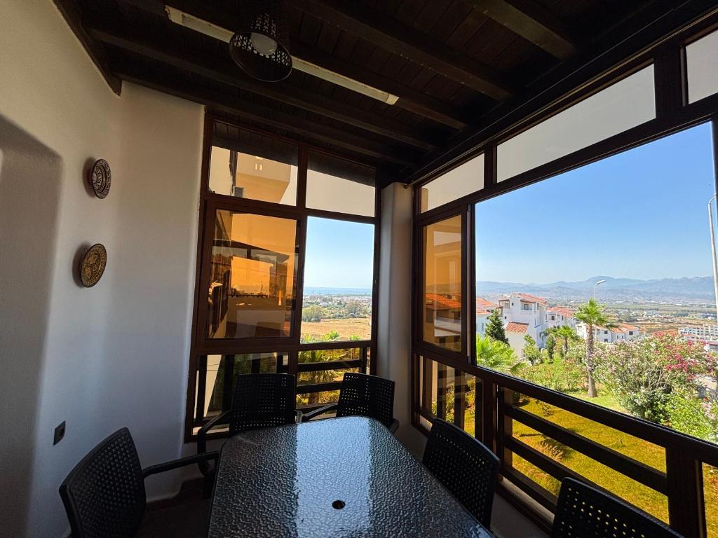 Un balcón con mesa y sillas y ventanas. en Cabo Dream - Cabo, en Cabo Negro