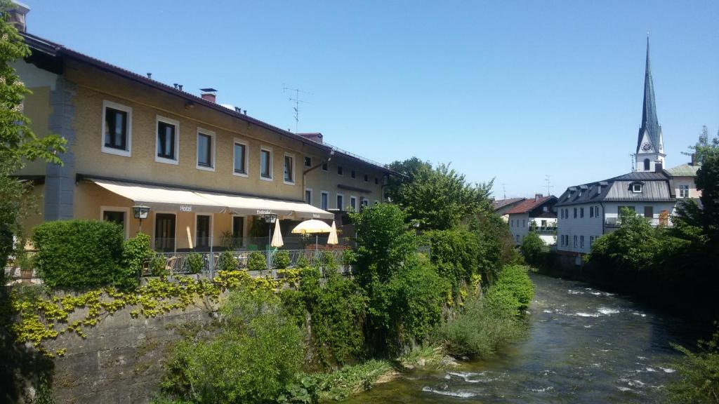 a river in front of a building and a river at Hotel Pension Lindenhof in Prien am Chiemsee