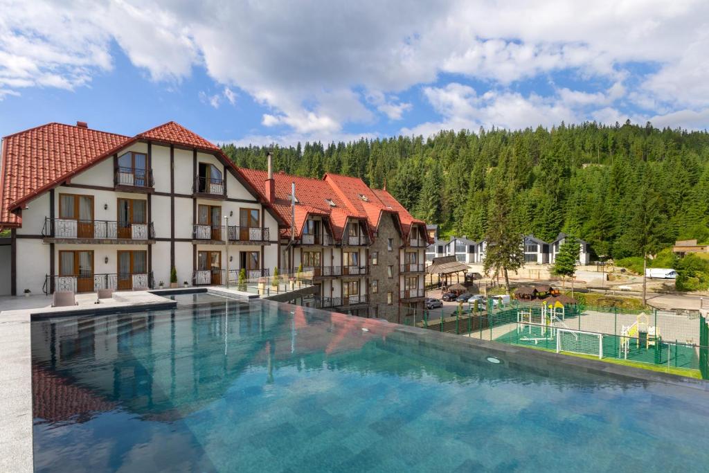 a large swimming pool in front of a building at Villa Nikoletta SPA in Bukovel