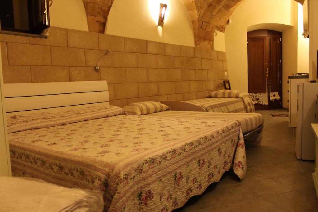 Zimmer mit 3 Betten in einem Gebäude in der Unterkunft La Grotta Del Cavaliere in Gravina in Puglia