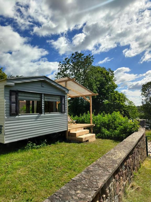 una casa pequeña sentada en la cima de un campo de hierba en Domek z widokiem na jezioro, en Jora Wielka