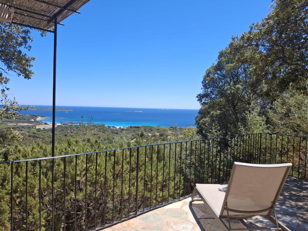 a patio with a chair and a view of the ocean at Résidence Belvedere de Palombaggia in Porto-Vecchio