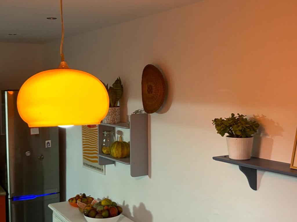 a kitchen with a yellow light hanging from the ceiling at La casita de los Tendederos in Tamaduste