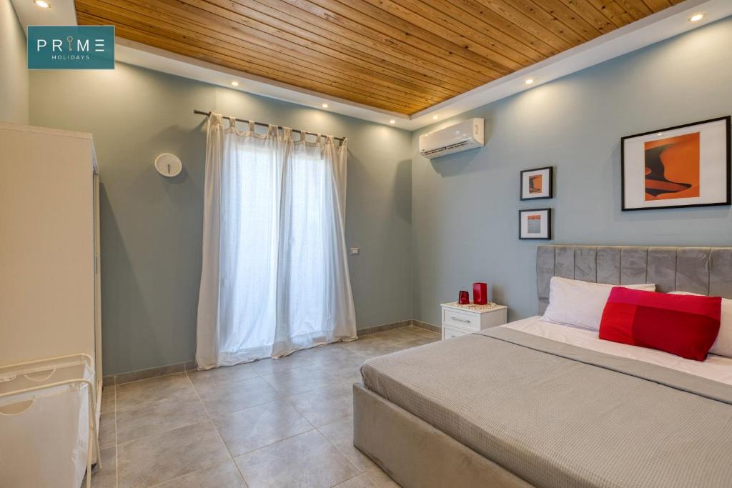 a bedroom with a bed and a wooden ceiling at Prime Holidays Mountain View Ras ElHekma in Ras Elhekma