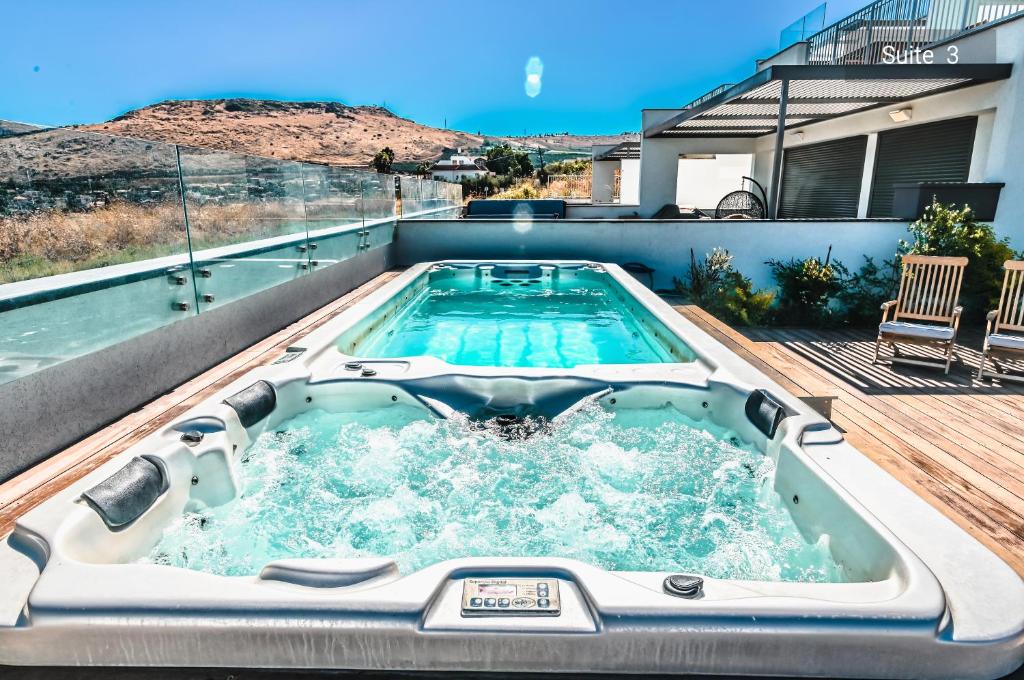 uma banheira de hidromassagem no deque de uma casa em Magdala Resort 2BR With private pool em Migdal