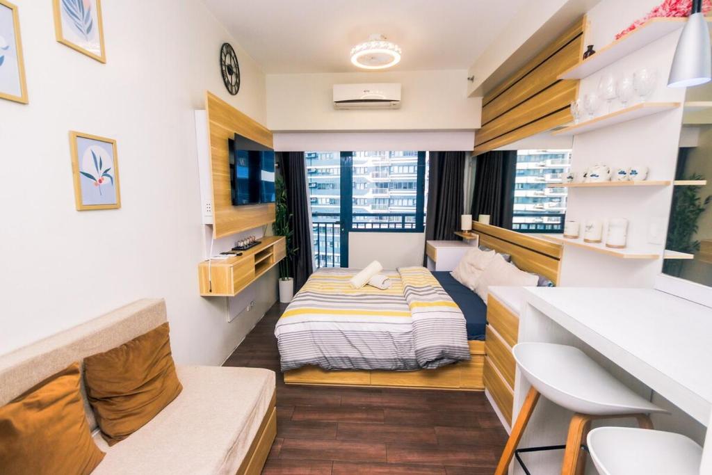 a small room with a bed and a desk at Netflix & Chill Stylish Makati condo gym swim park internet fast 2474 in Manila