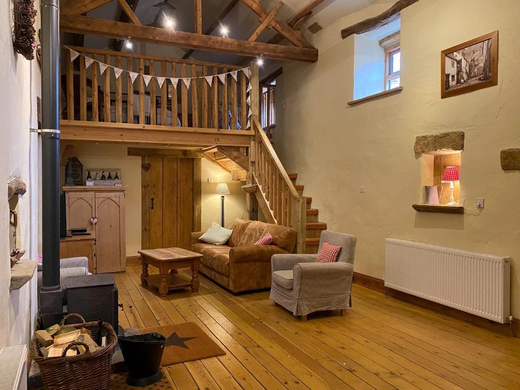 a living room with a staircase and a couch at Finkle Barn in Fryup