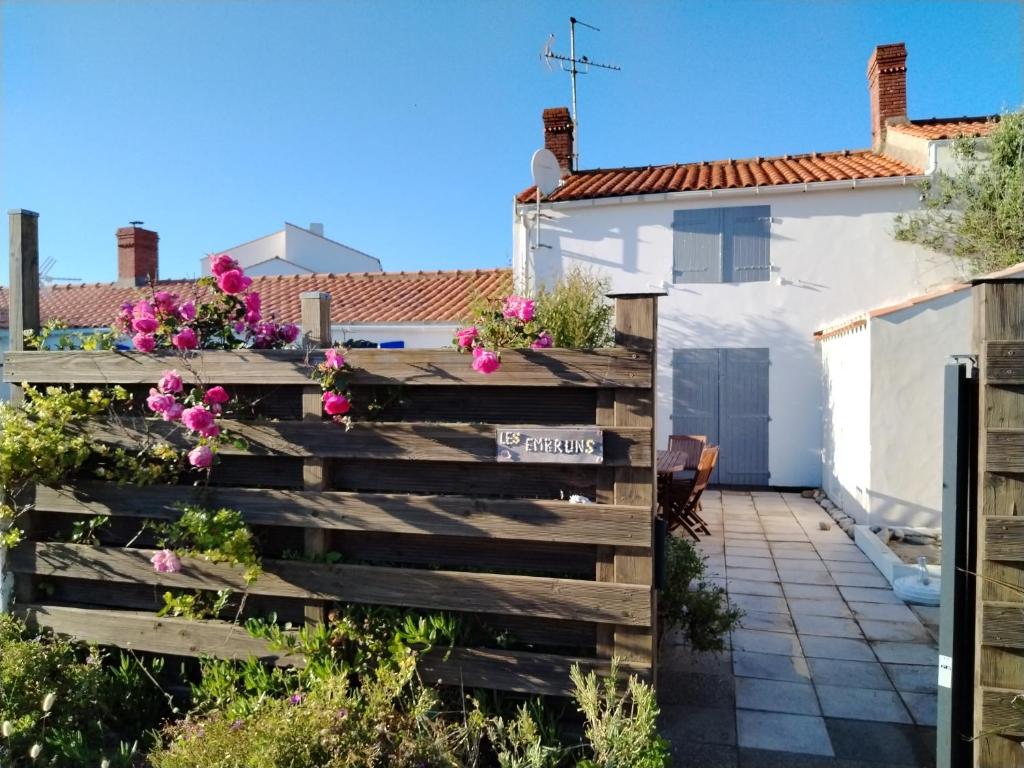 einen Garten mit Blumen auf einem Holzzaun in der Unterkunft Noirmoutier house 6 to 8 people in Noirmoutier-en-l'lle