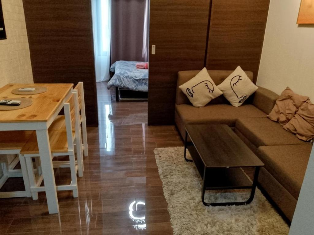 un salon avec un canapé et une table dans l'établissement The Kings Condo Luxury 1BR Makati Ayala Gym Swim Parking Fast Internet 3058, à Manille