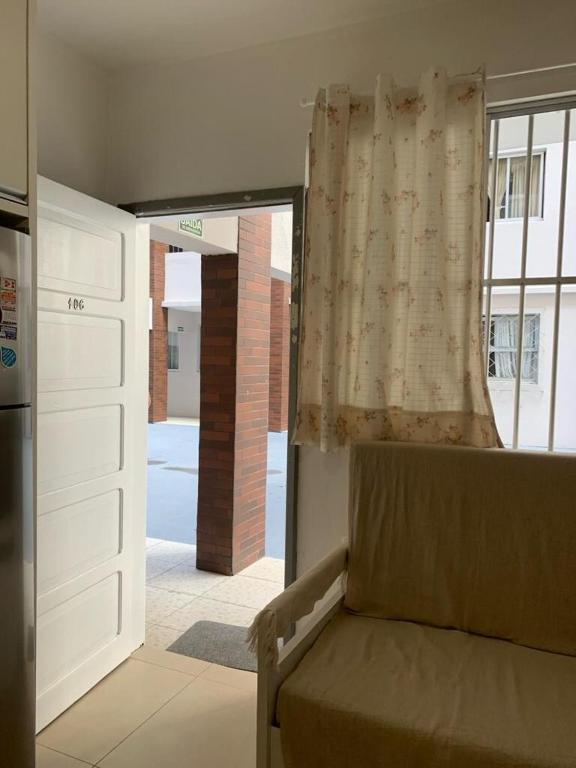Habitación con cama y ventana con cortina en Seaside apartment, AV Atlantic, en Balneário Camboriú