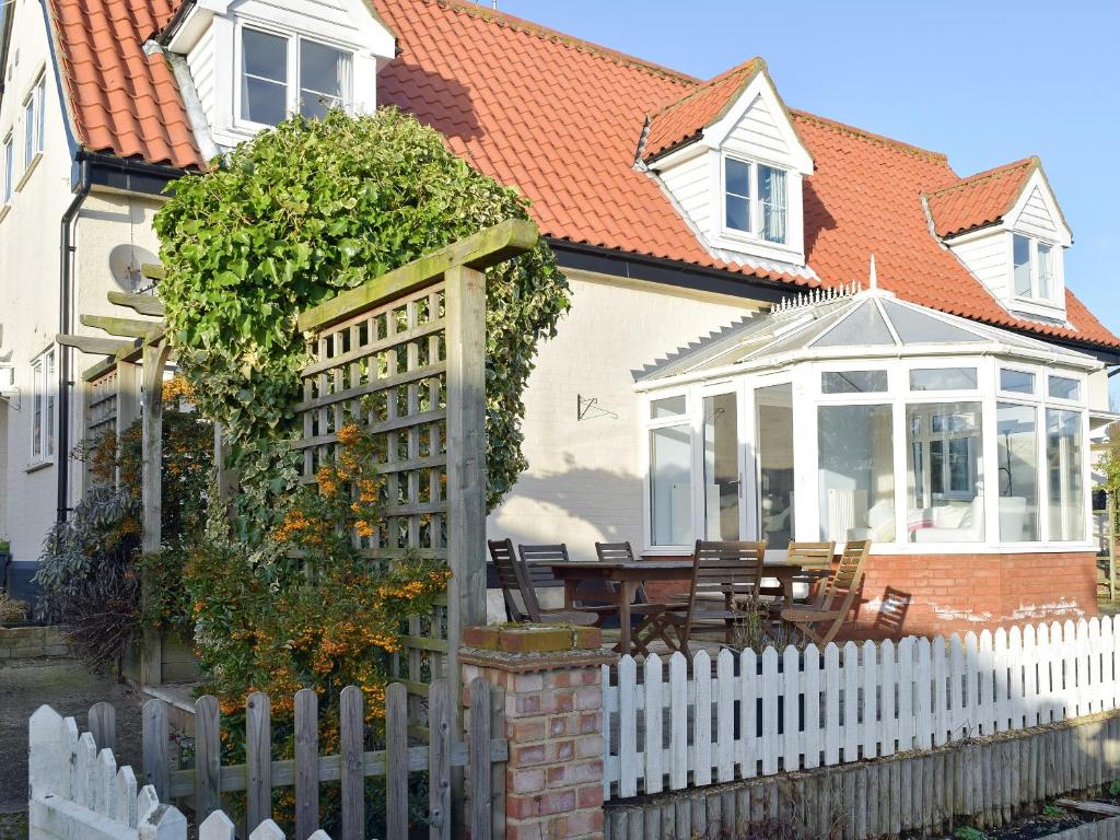 a white fence in front of a house at Granary Cottage in Bentley
