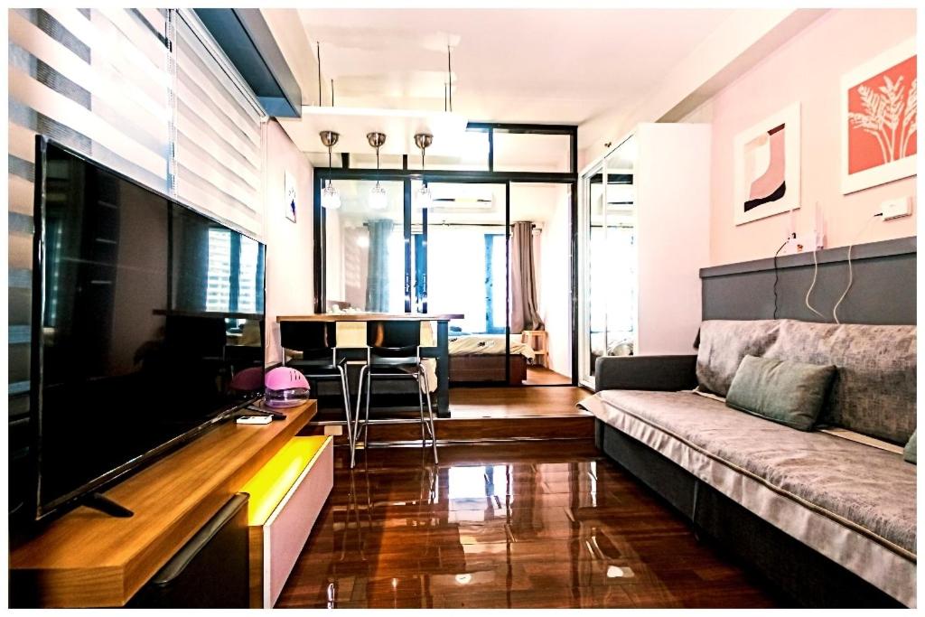 a living room with a couch and a table at City Best Designer 1BR Makati Fast internet Gym Swim Park 2050 in Manila