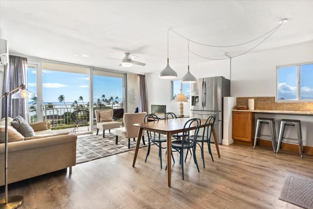 キヘイにあるBeautiful Oceanfront Condoのテーブルと椅子のあるキッチンとリビングルーム